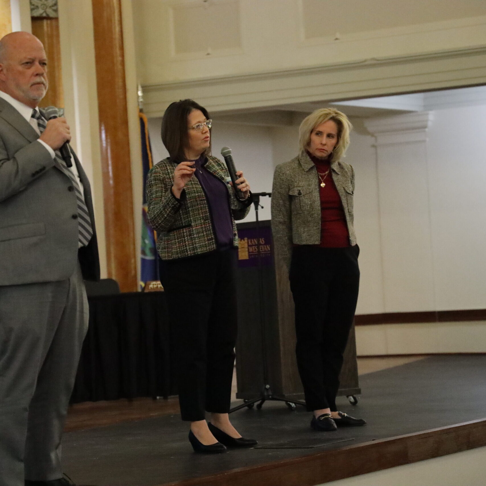 Three individuals on stage with mics