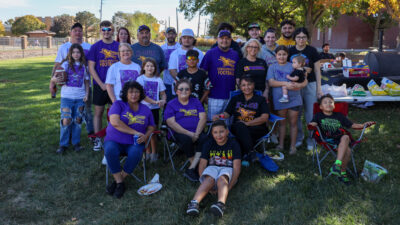 Family of football player at homecoming under tree