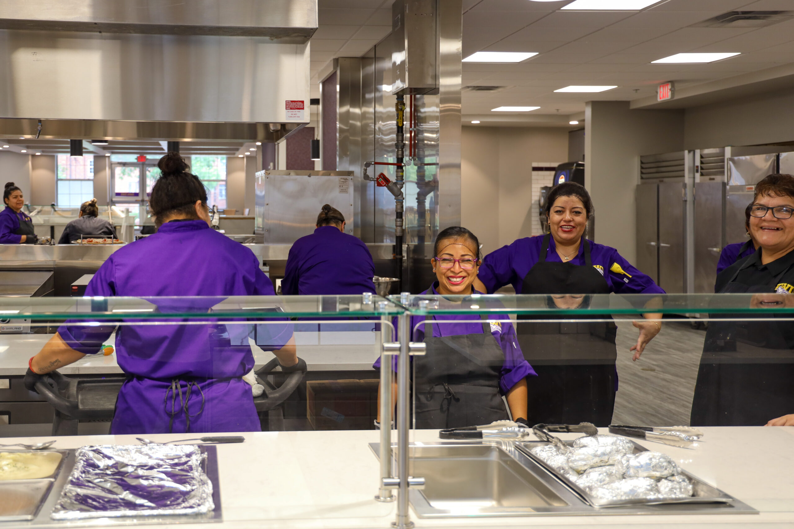 People waiting to serve food behind counter