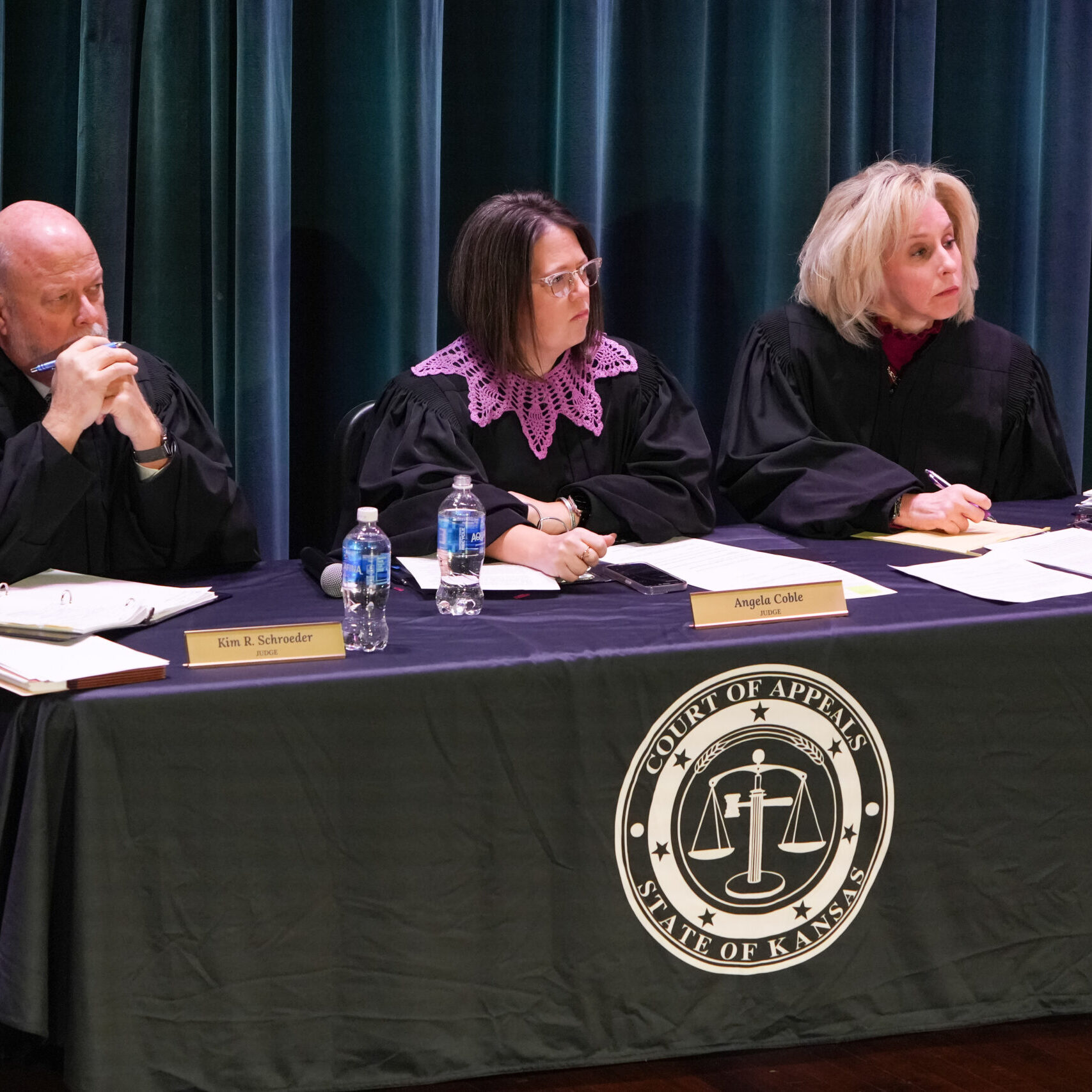 Three judges in robes at table