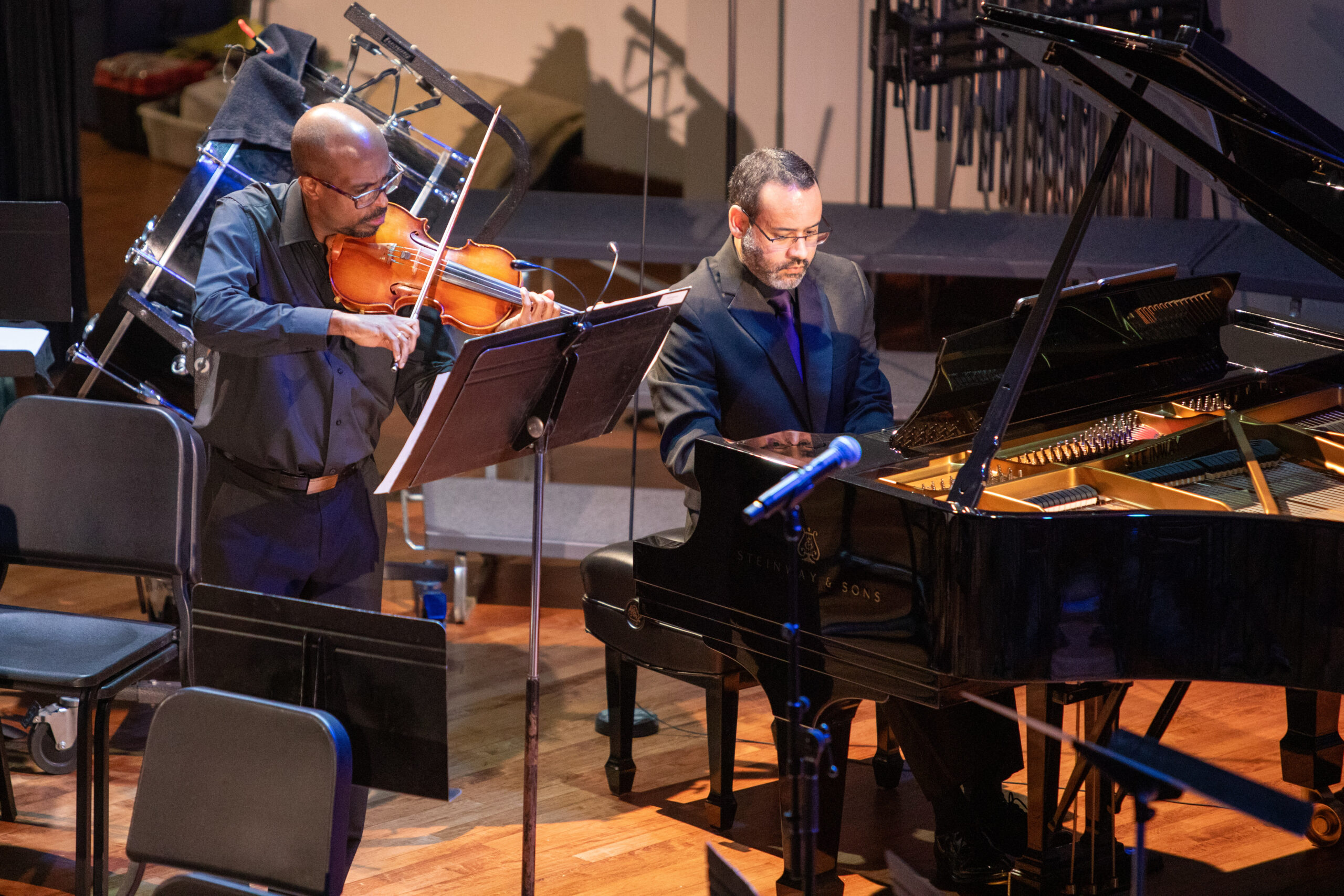 Man playing violin, another playing piano