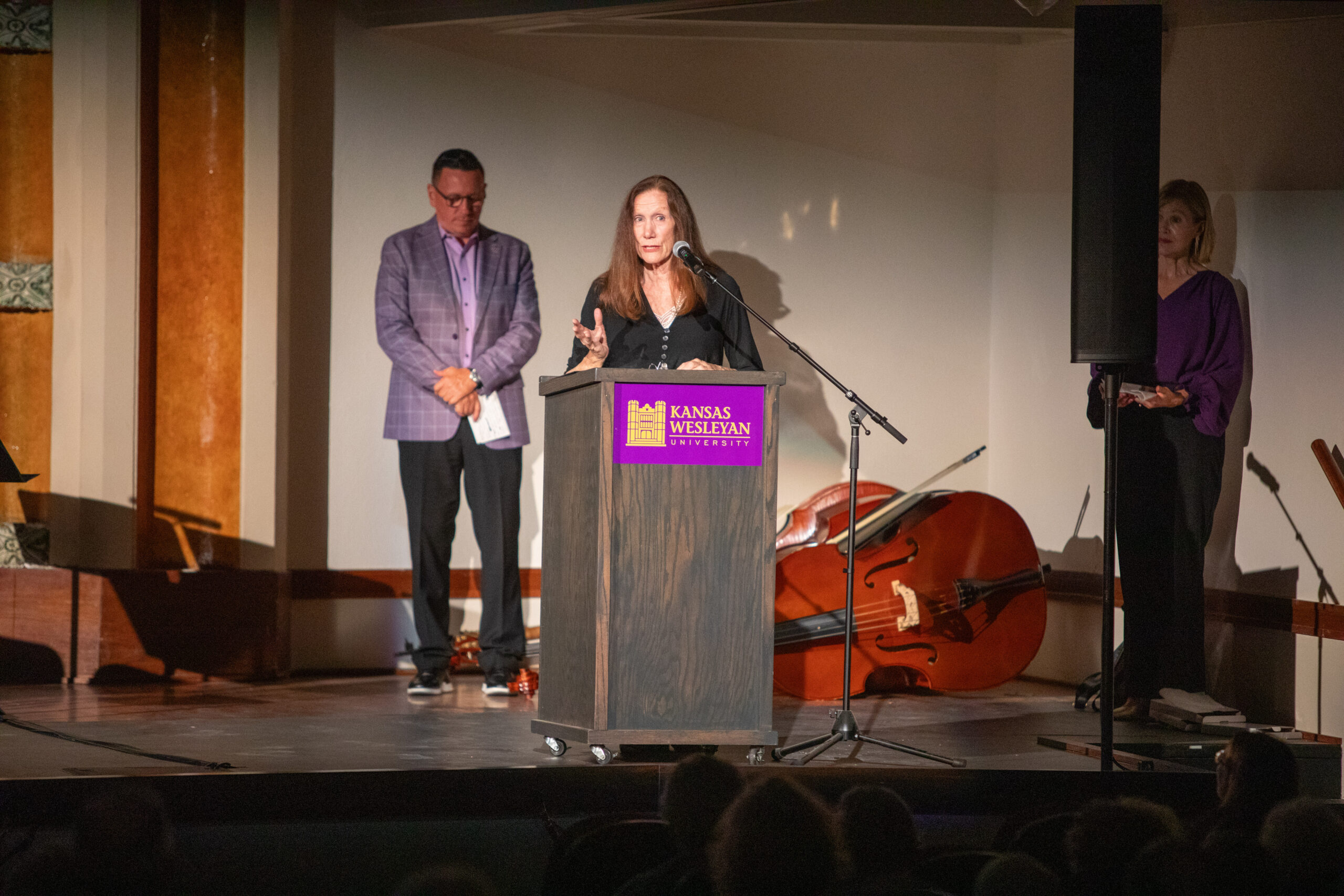 Woman speaking at podium, man behind