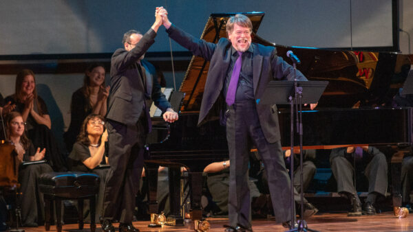 Men raising hands after operatic song