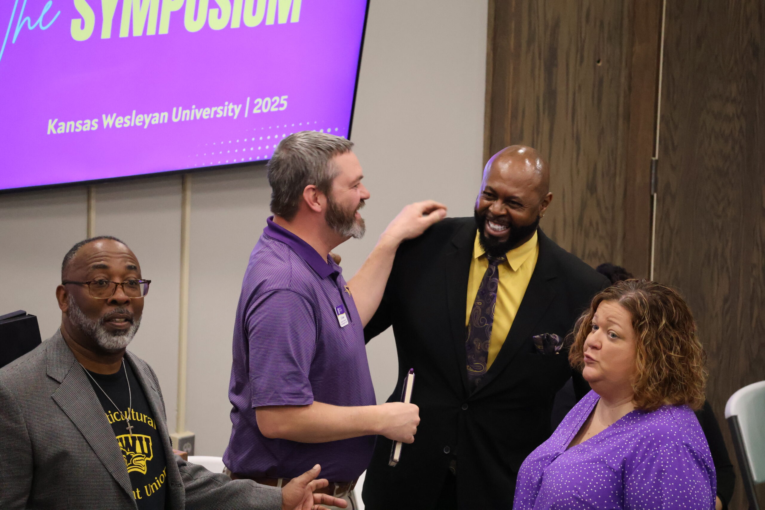 Man with hand on shoulder and people laughing