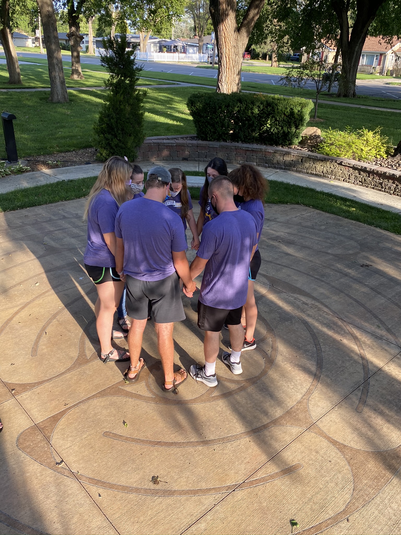 Group of people gathered around outside praying