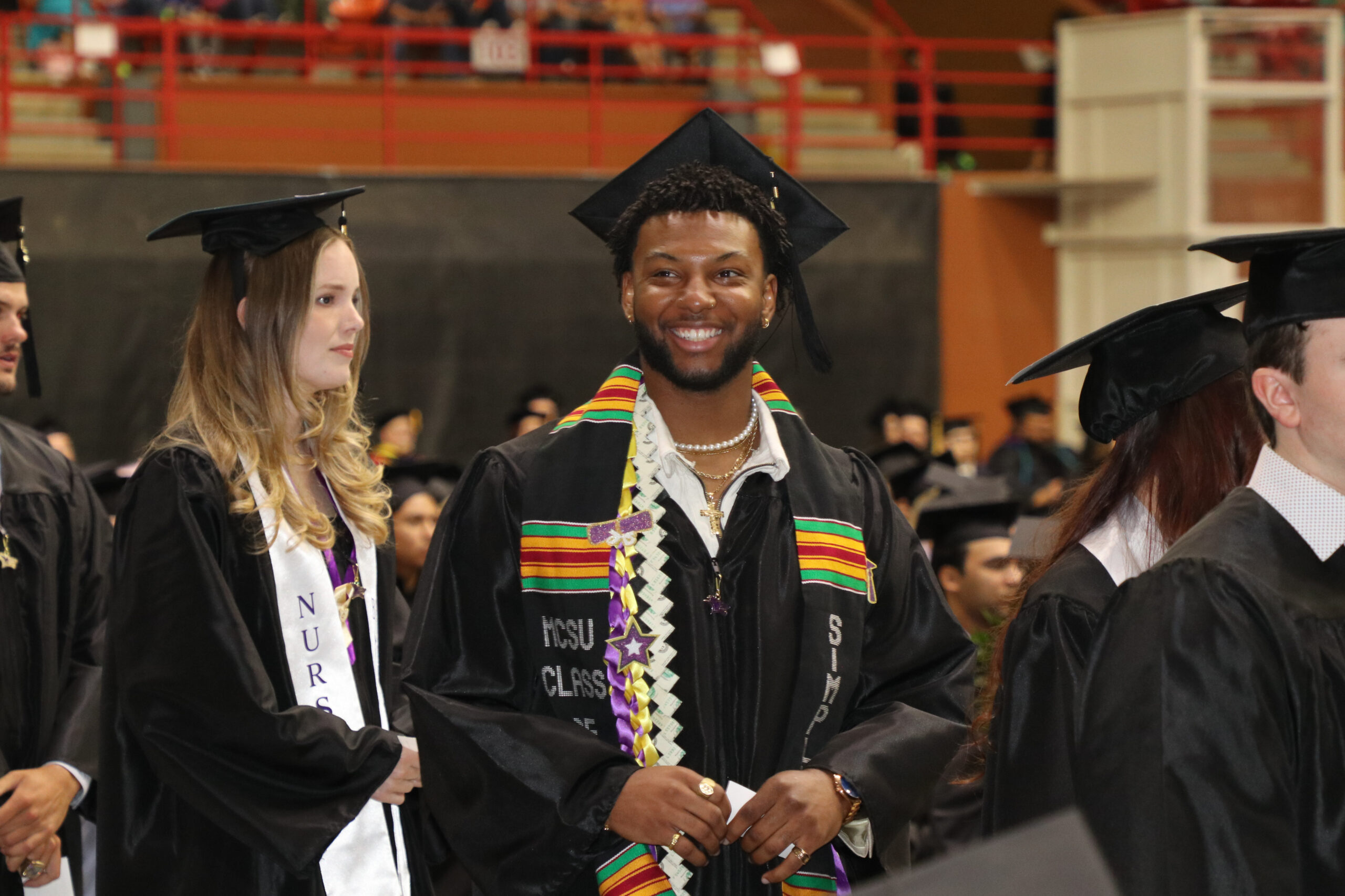Man in graduation attire smiling