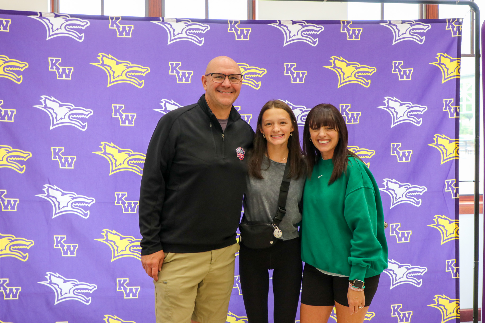 Parent and student posing in front of photo backdrop