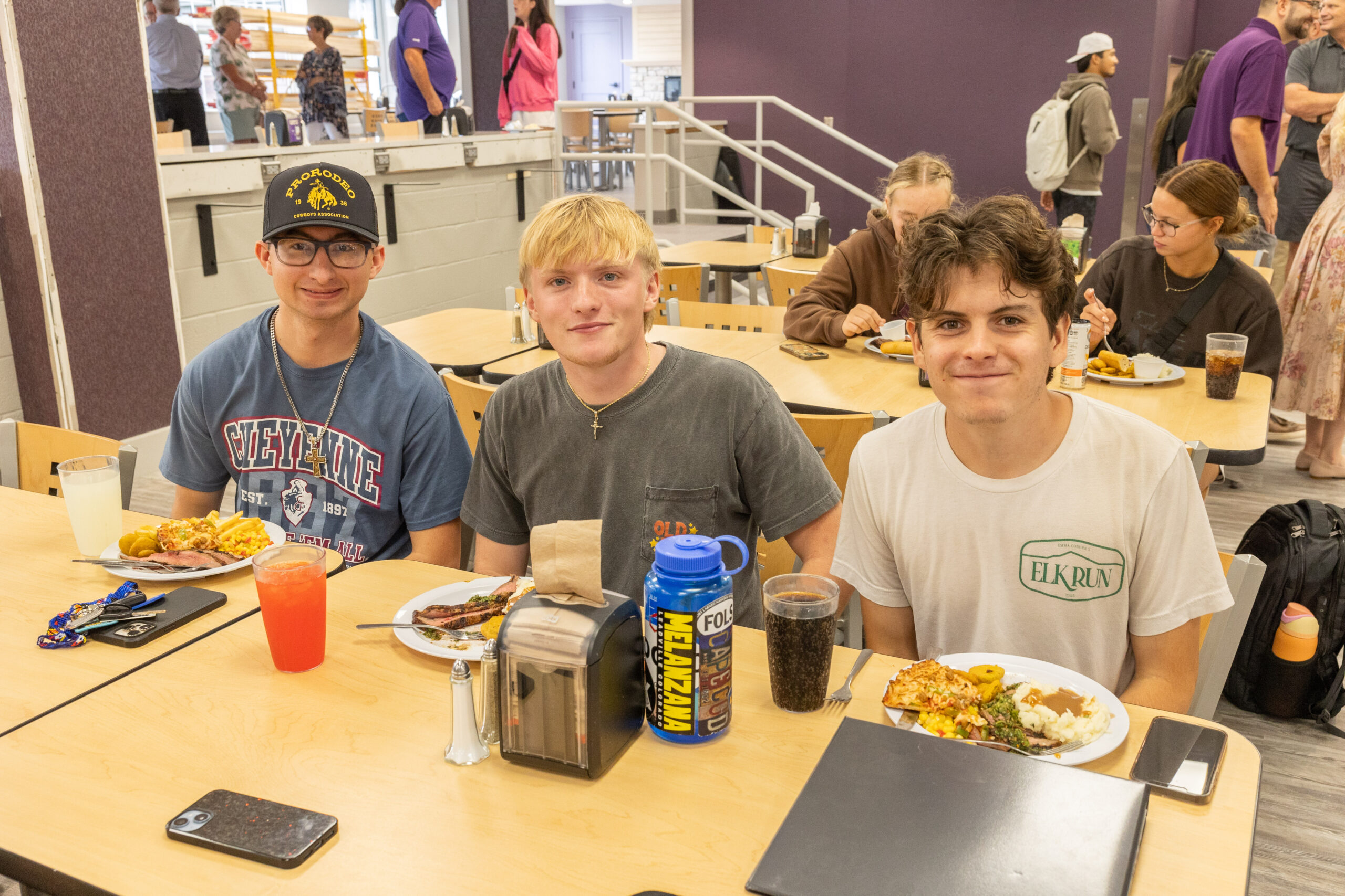 Three male students eating food